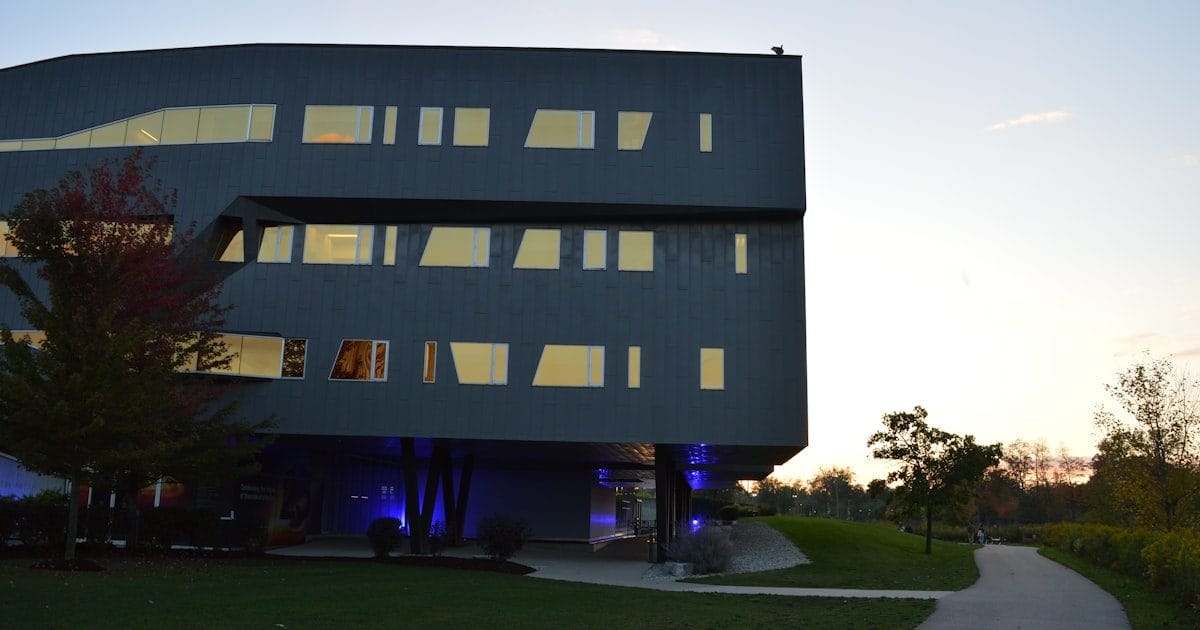 Modern research building with glowing glass facade at dusk